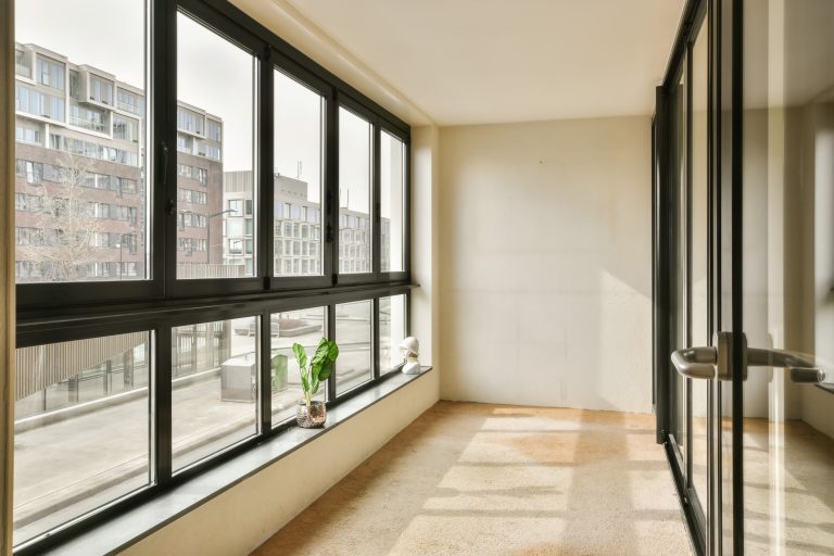 a living room with large windows and a tile floor